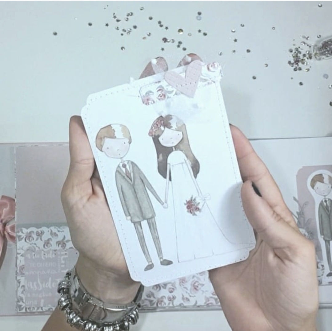 Cartão decorativo de casal de noivos segurado por mãos femininas