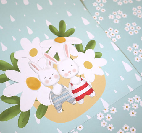 Figuras de coelhos de peluche entre flores brancas sobre fundo azul claro com padrão de pequenas flores e gotas