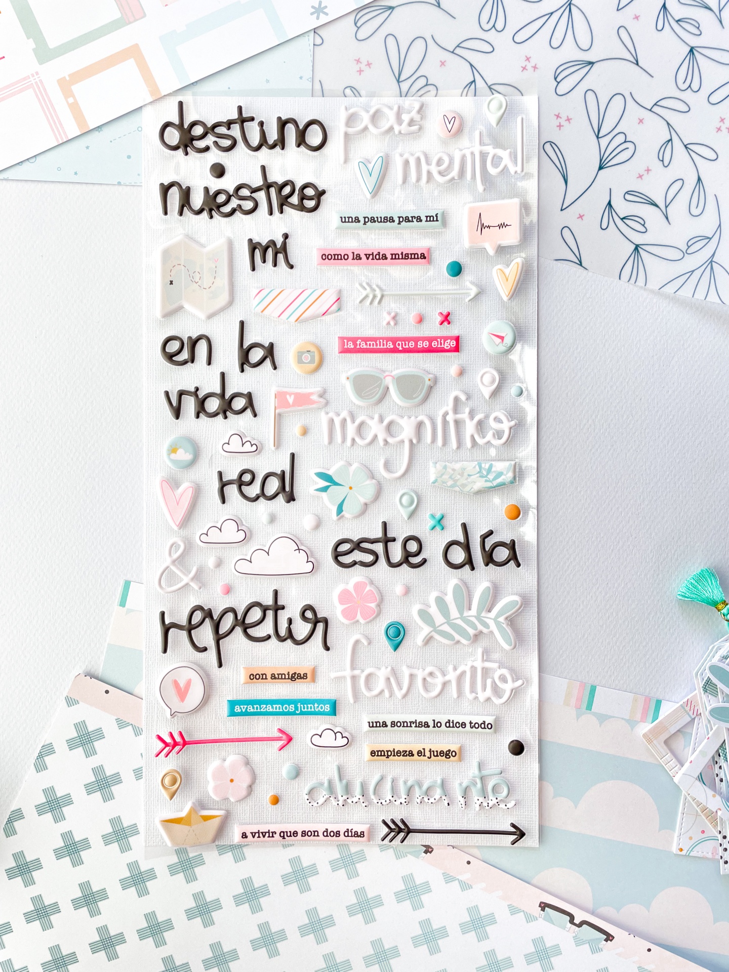 Folha de autocolantes com texto e gráficos coloridos em fundo claro com papéis decorativos ao fundo