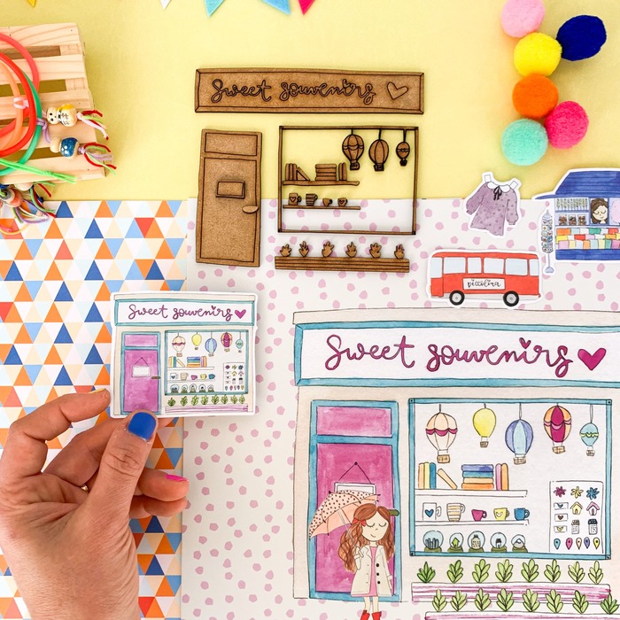 Ilustração colorida mostrando uma loja Sweet souvenirs com vários recortes de papel e uma mão segurando uma peça pequena.