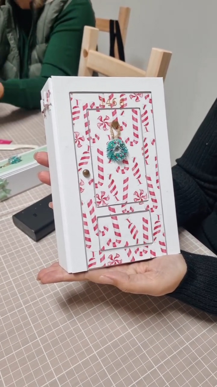 Caixa decorativa branca com padrão de bengalas doces e guirlanda verde azul