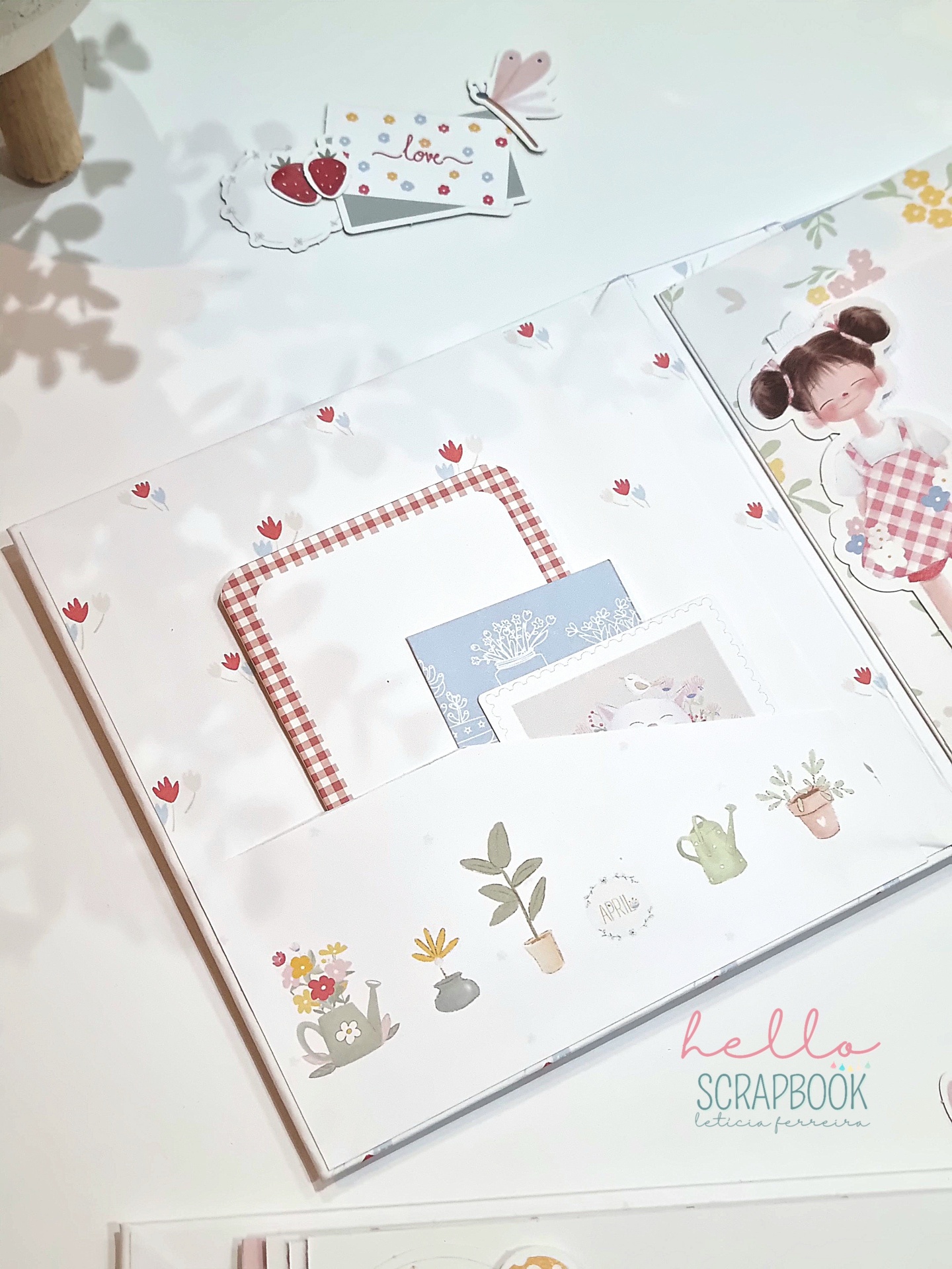 Caderno de scrapbook com decoração floral e cartões de papel