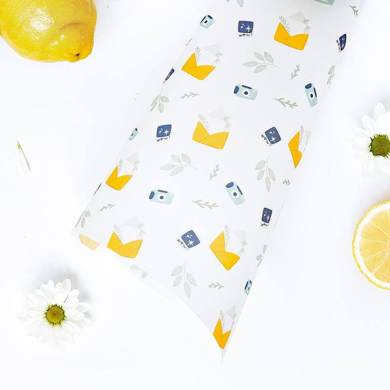 Embalagem branca com padrão colorido e elementos naturais ao redor