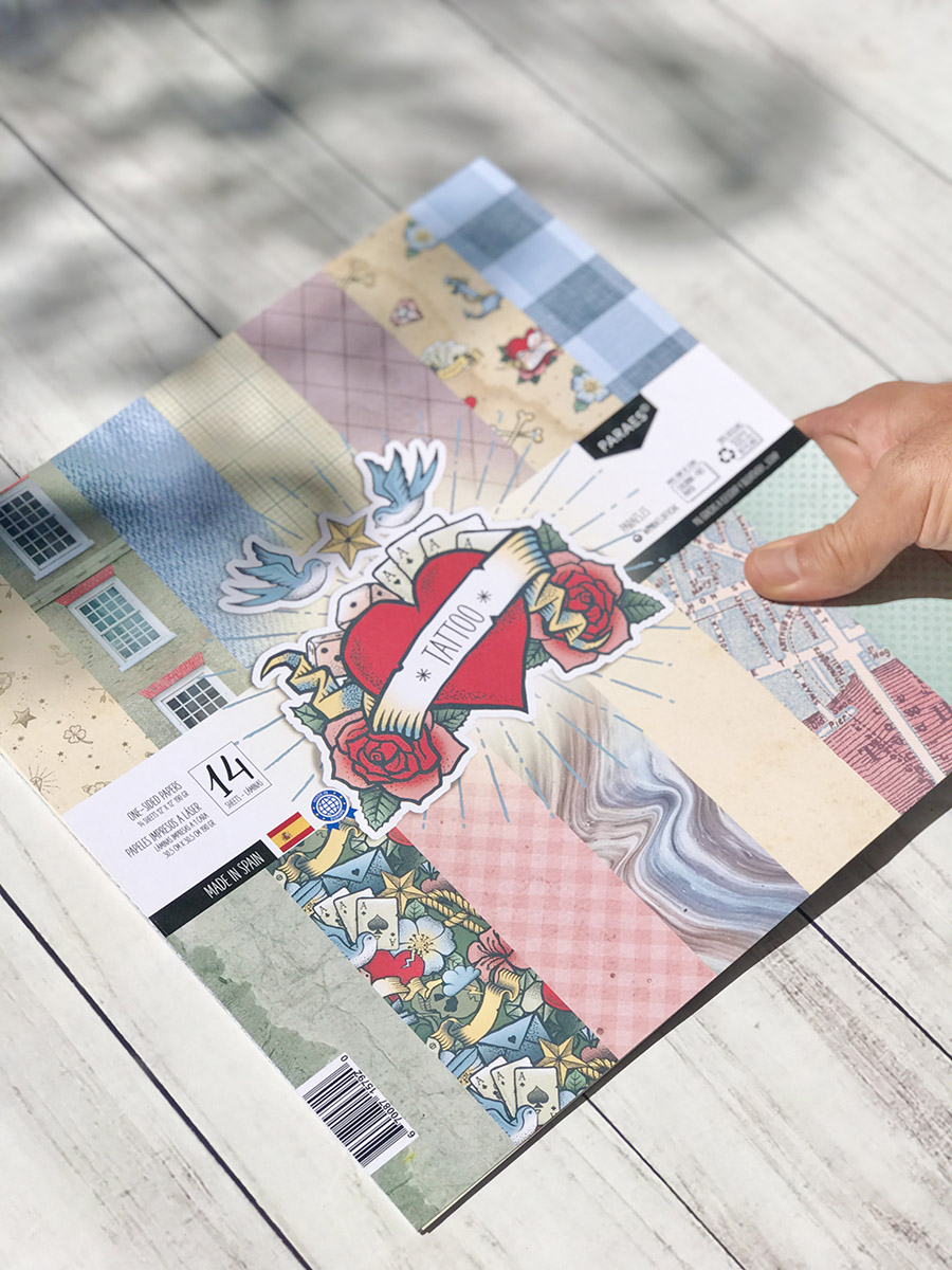 Folha de papel decorativo com várias estampas e etiqueta TATTOO sobre uma mesa branca