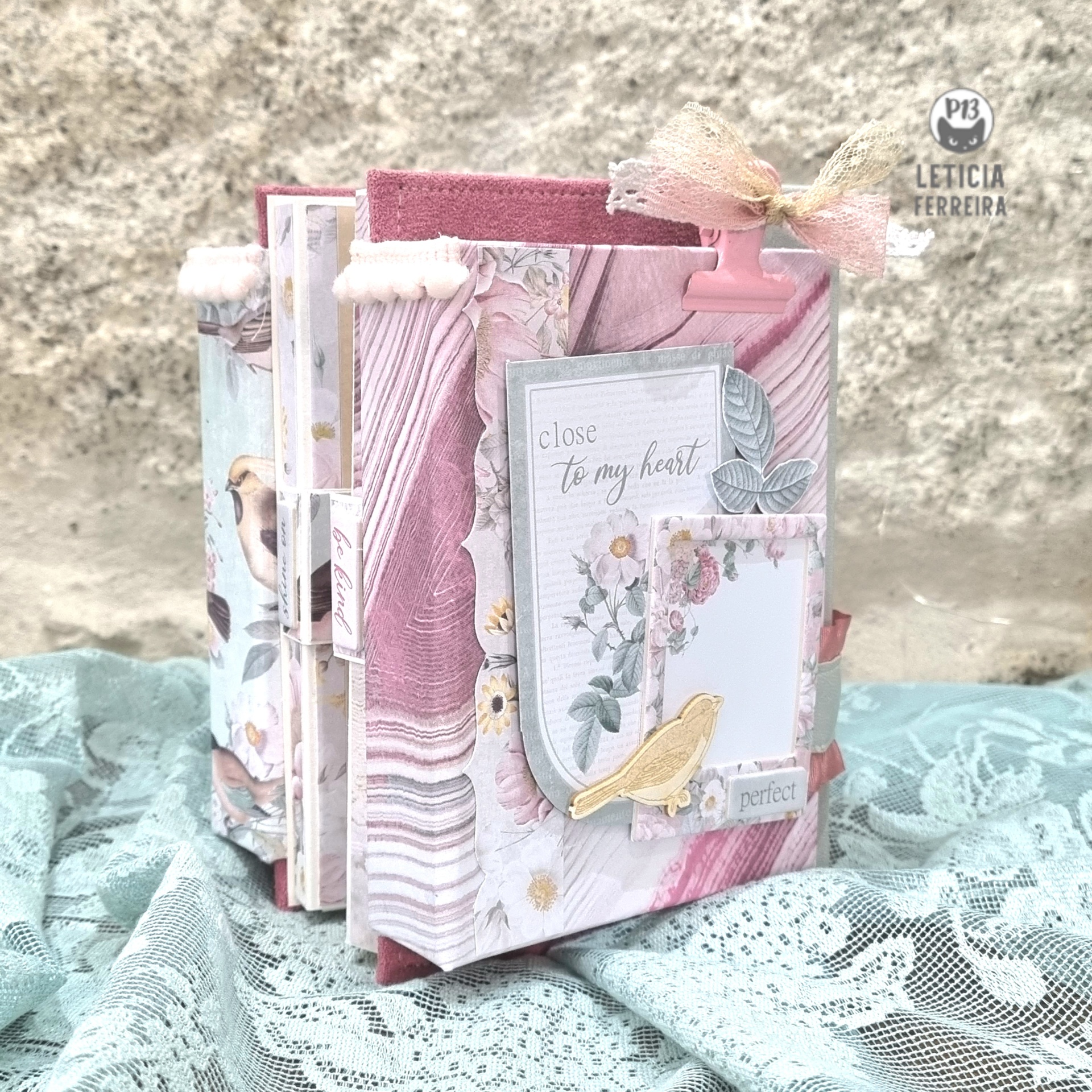 Livro artesanal decorativo com capa rosa e padrão floral com pássaros e laço de fita