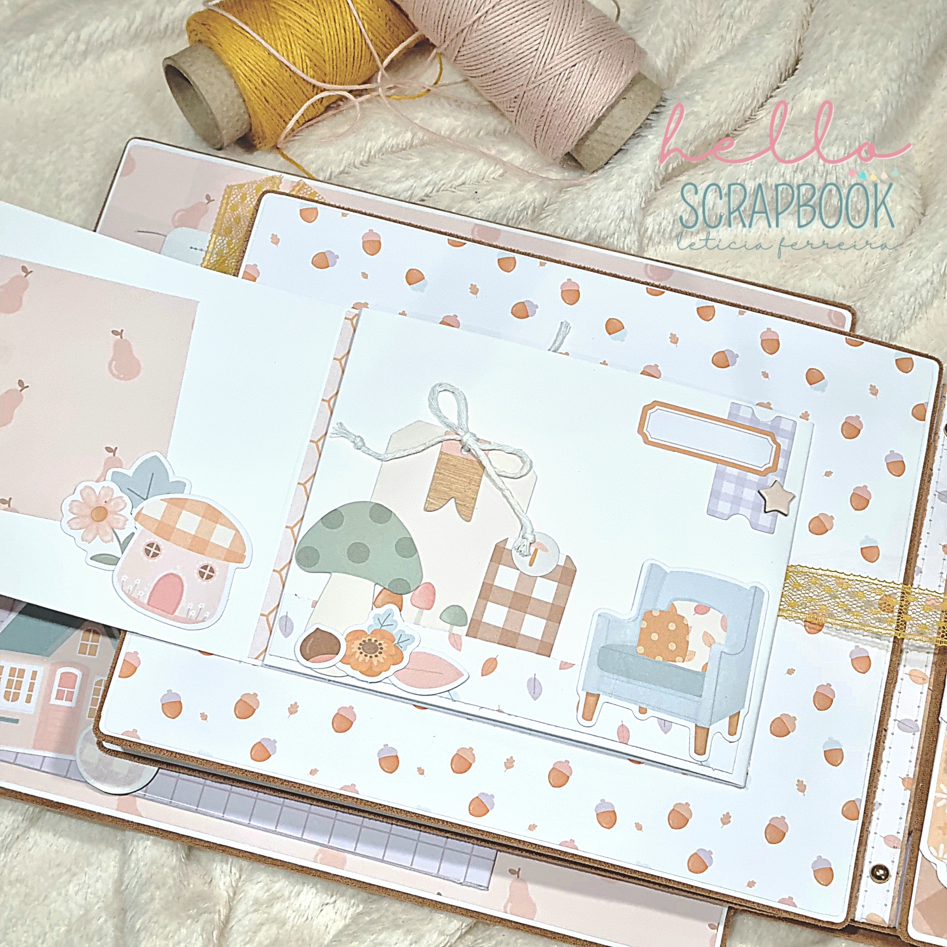 Álbum de scrapbook com decoração de cogumelos, flores e cadeira azul, com rolos de fio amarelo e bege