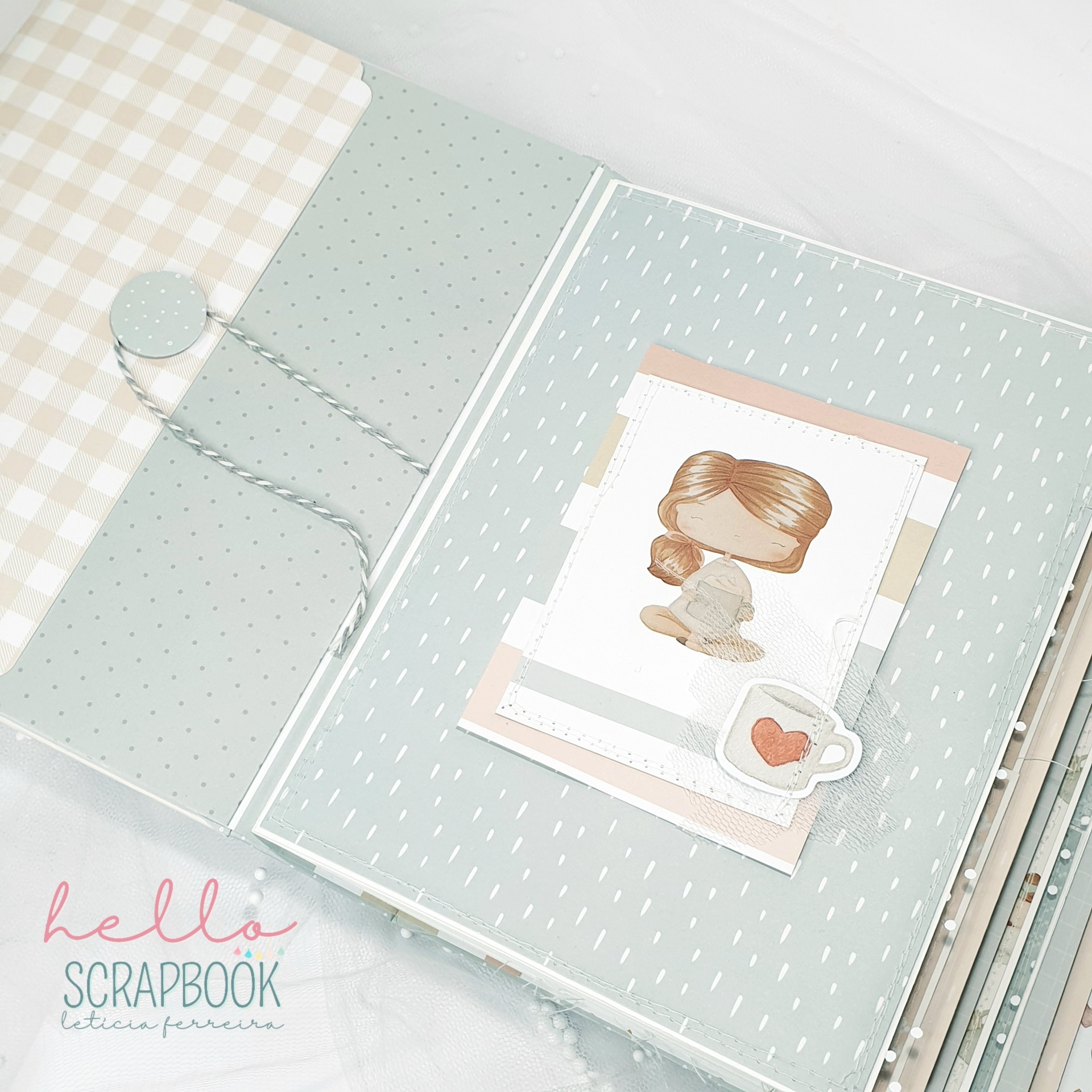 Scrapbook verde aberto com desenhos e fita decorativa em fundo branco