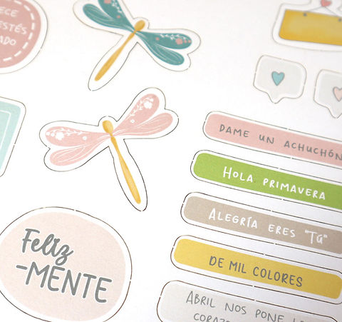 Autocolantes coloridos com desenhos e frases em espanhol sobre superfície branca