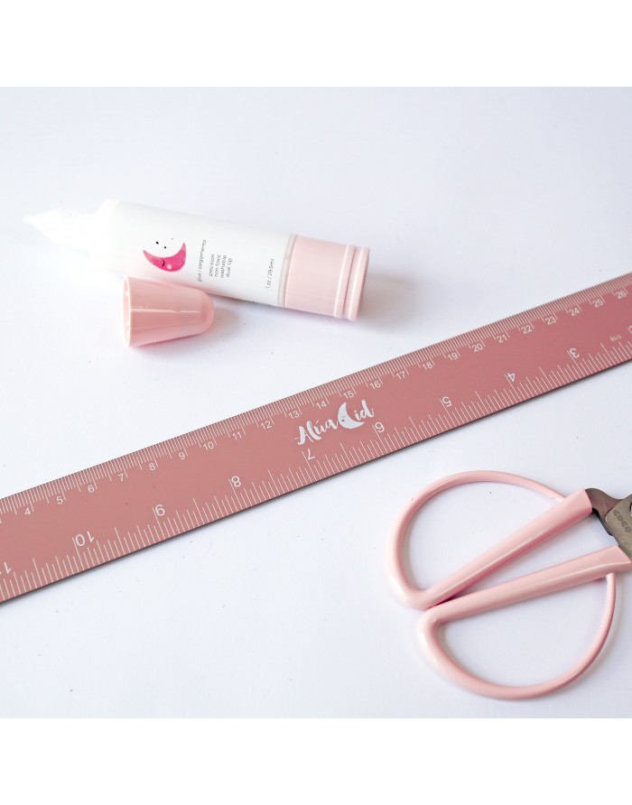 Régua rosa com marca Mia Cat, tesoura rosa e tubo branco com tampa rosa sobre fundo branco