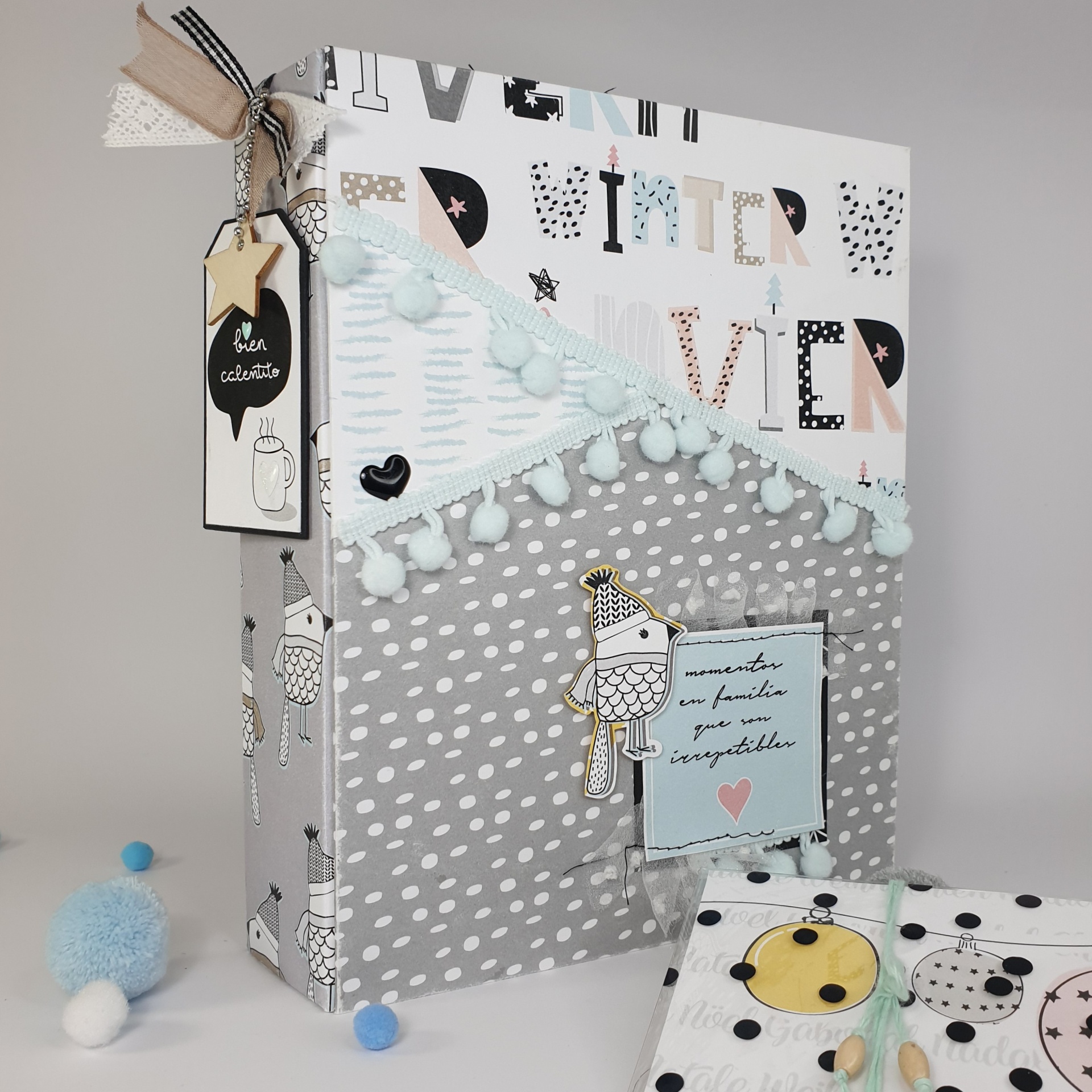 Caixa decorativa cinza com estampas de coruja e detalhes azuis com pompons e etiquetas coloridas