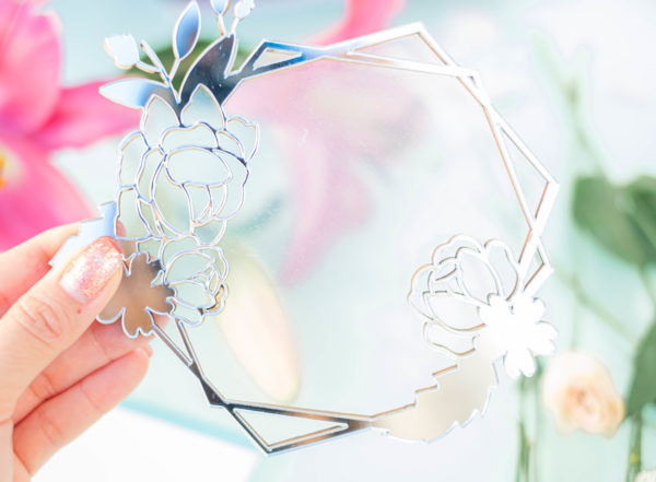 Espelho decorativo com moldura geométrica e flores recortadas