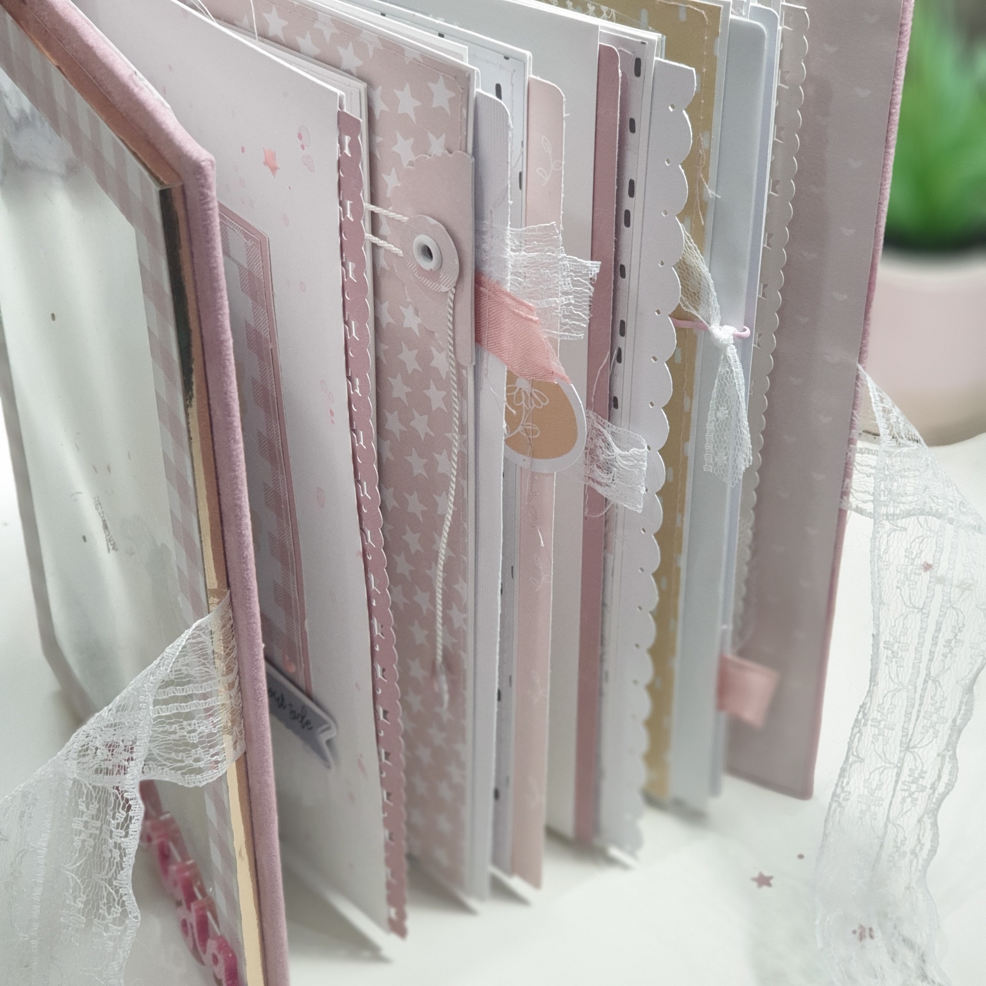 Livro de scrapbook com páginas decoradas com fitas e padrões de estrelas em tons pastel