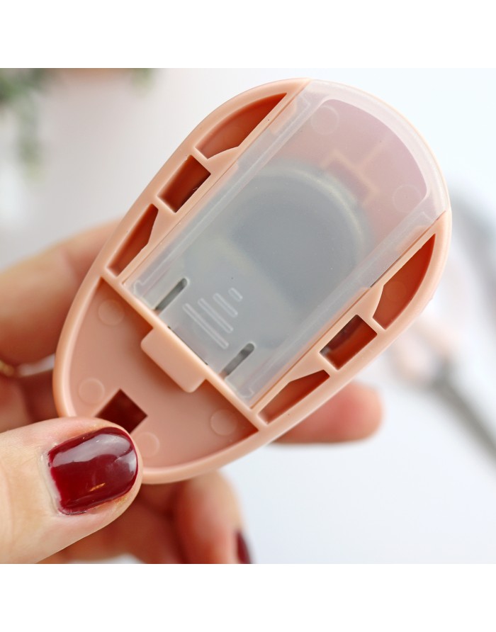 Dispositivo portátil cor de rosa com peça transparente segurado por mão com verniz vermelho