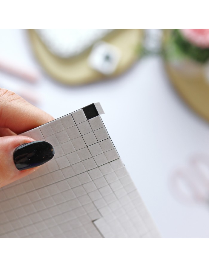 Mão segura régua de papel quadriculado branca com quadrículas cinza