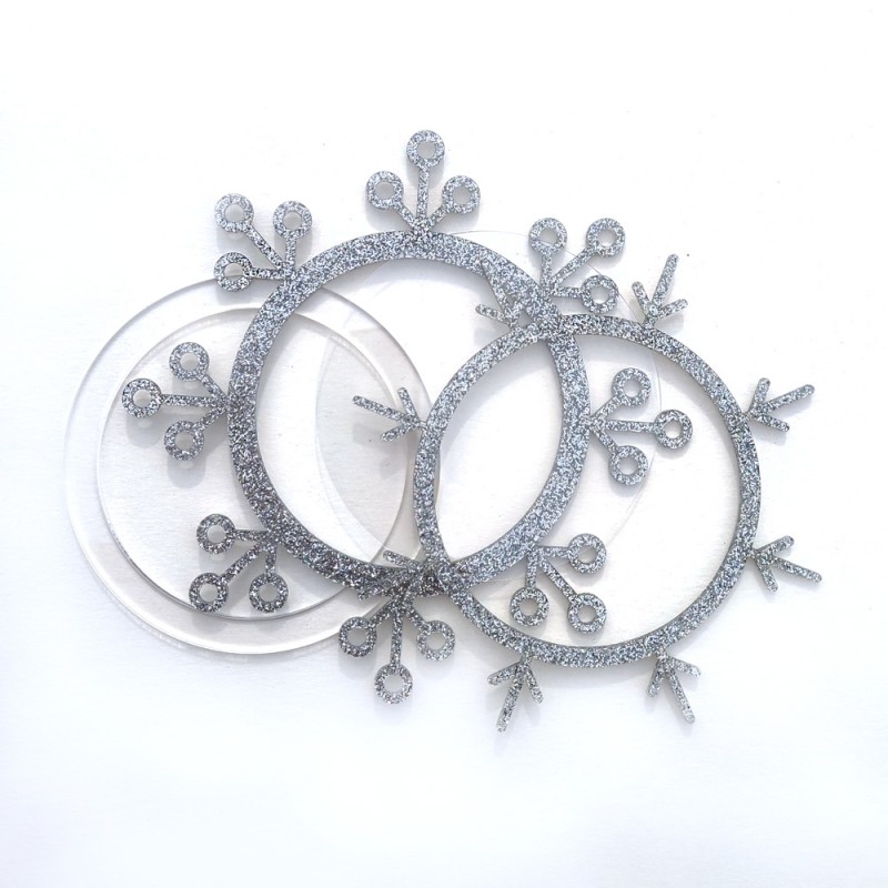 Três moldes redondos para artesanato em forma de flocos de neve com glitter prateado e transparente