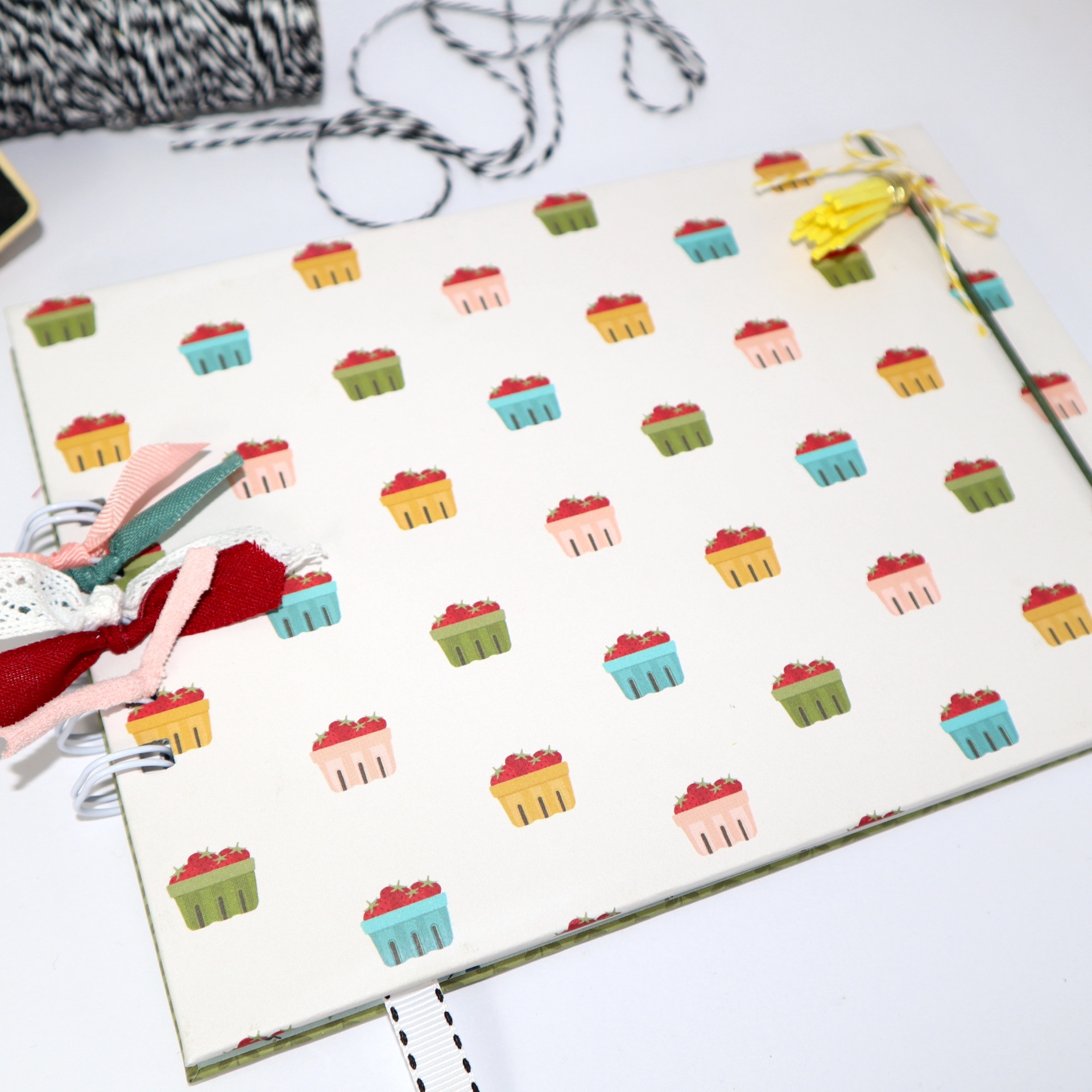 Caderno decorado com padrão de cupcakes coloridos e fitas na lateral