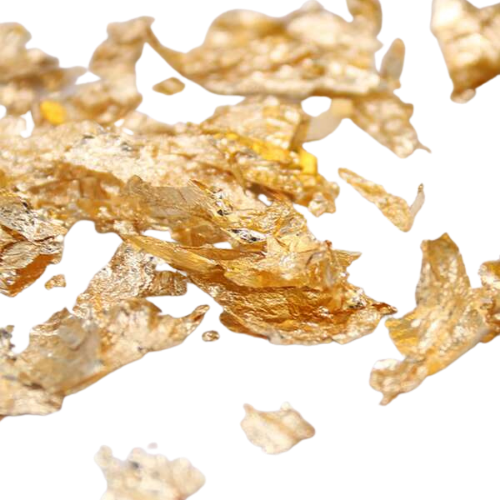 Folhas de ouro finas, translúcidas e amareladas dispersas em fundo branco