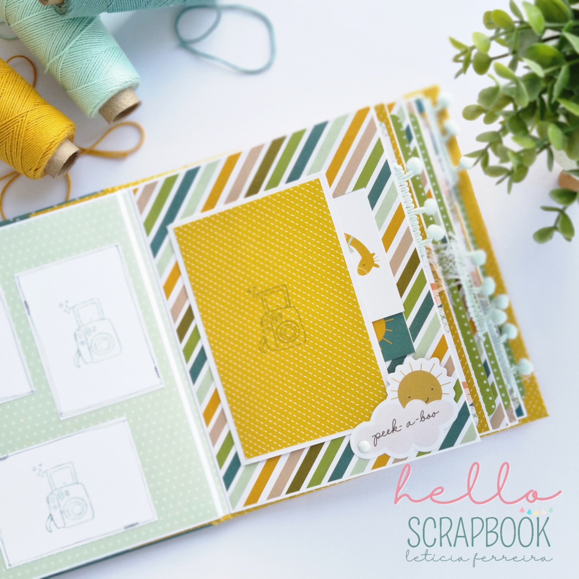 Álbum scrapbook colorido com padrões listrados e adesivos, junto a rolos de linha e planta