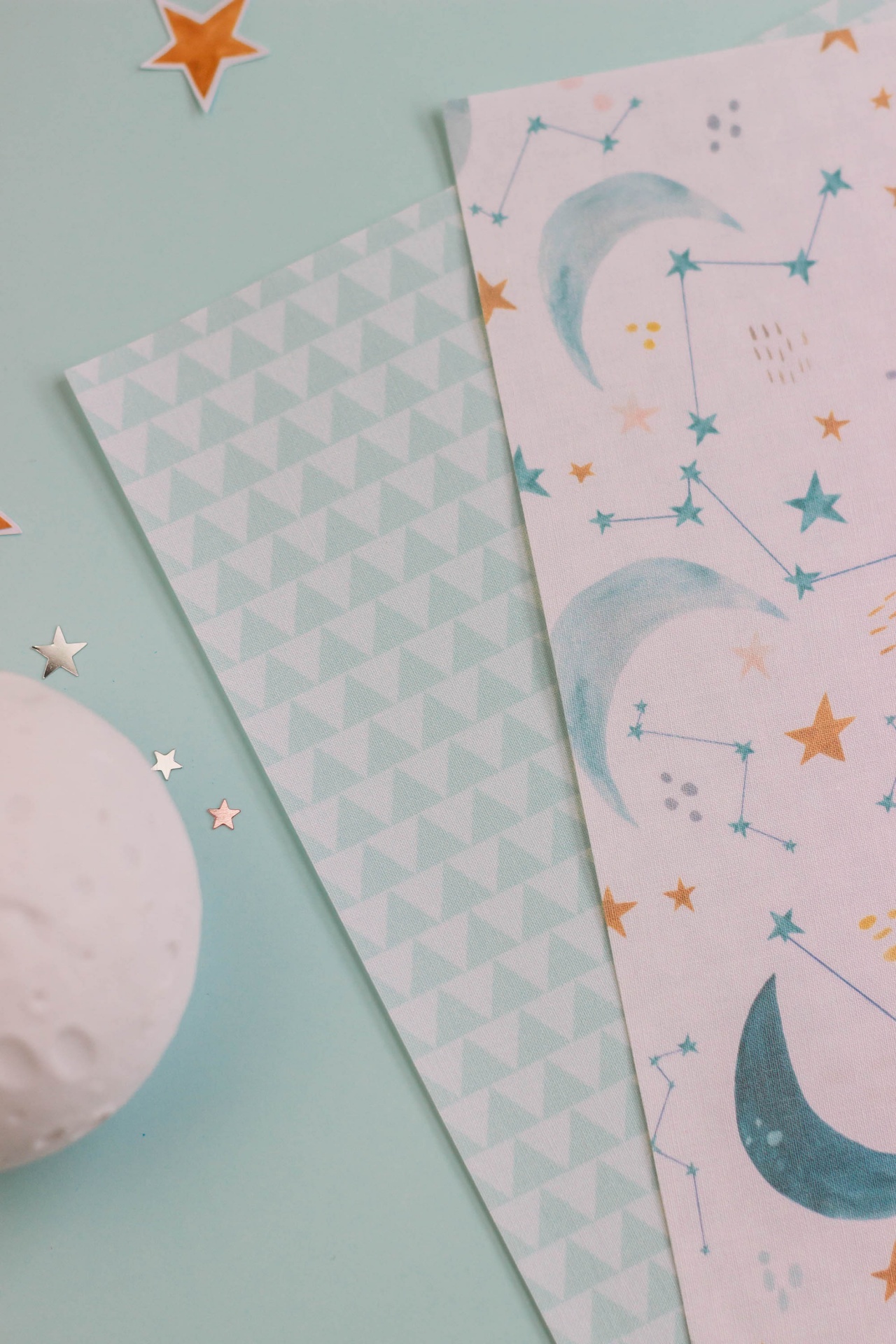 tecidos ou papéis decorativos com padrões de triângulos e constelações sobre fundo azul