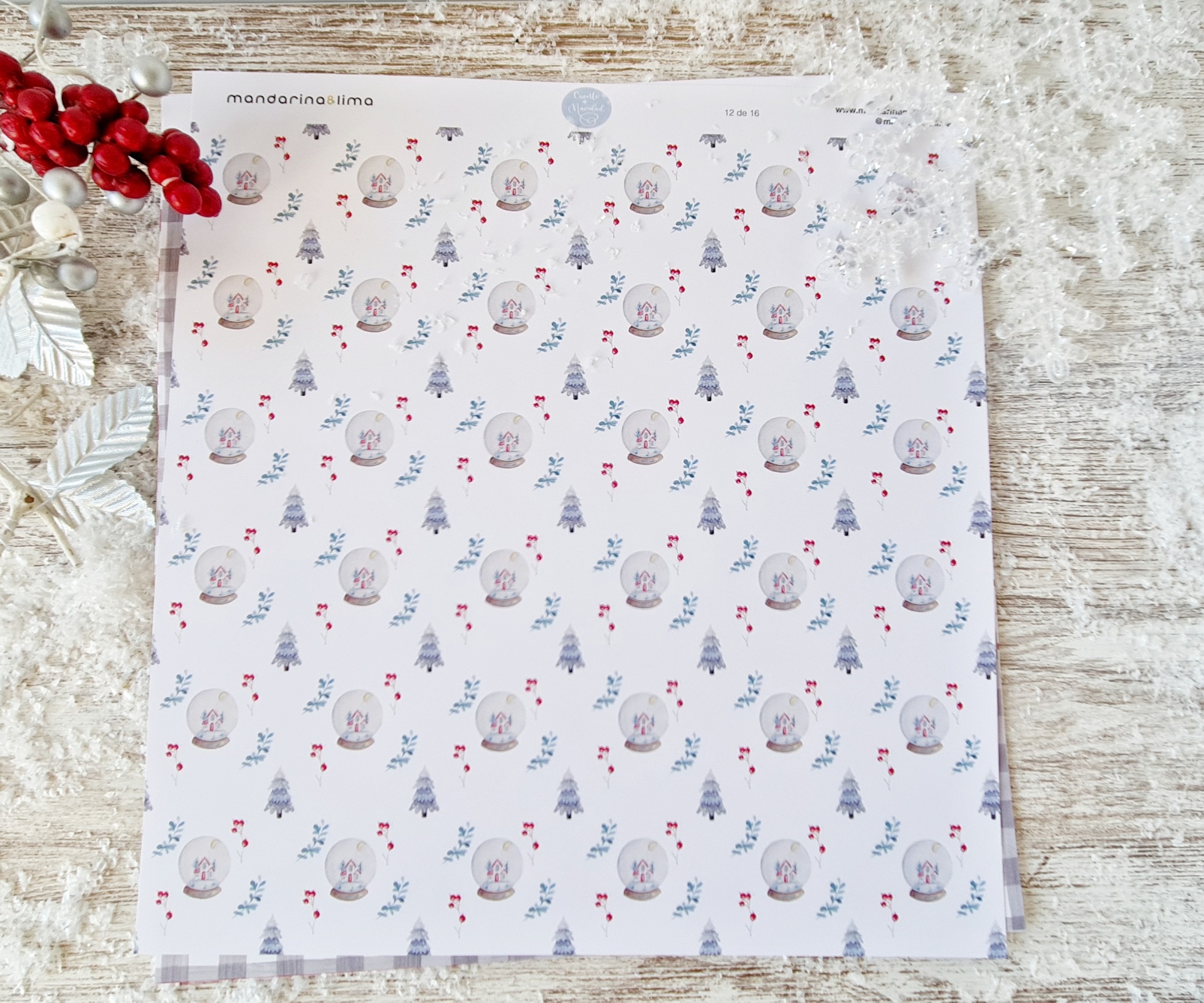 Papel de embrulho com padrão natalício azul, vermelho e branco sobre mesa de madeira clara