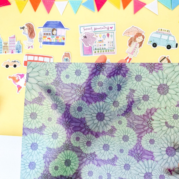 tecido floral verde e roxo com desenhos coloridos ao fundo