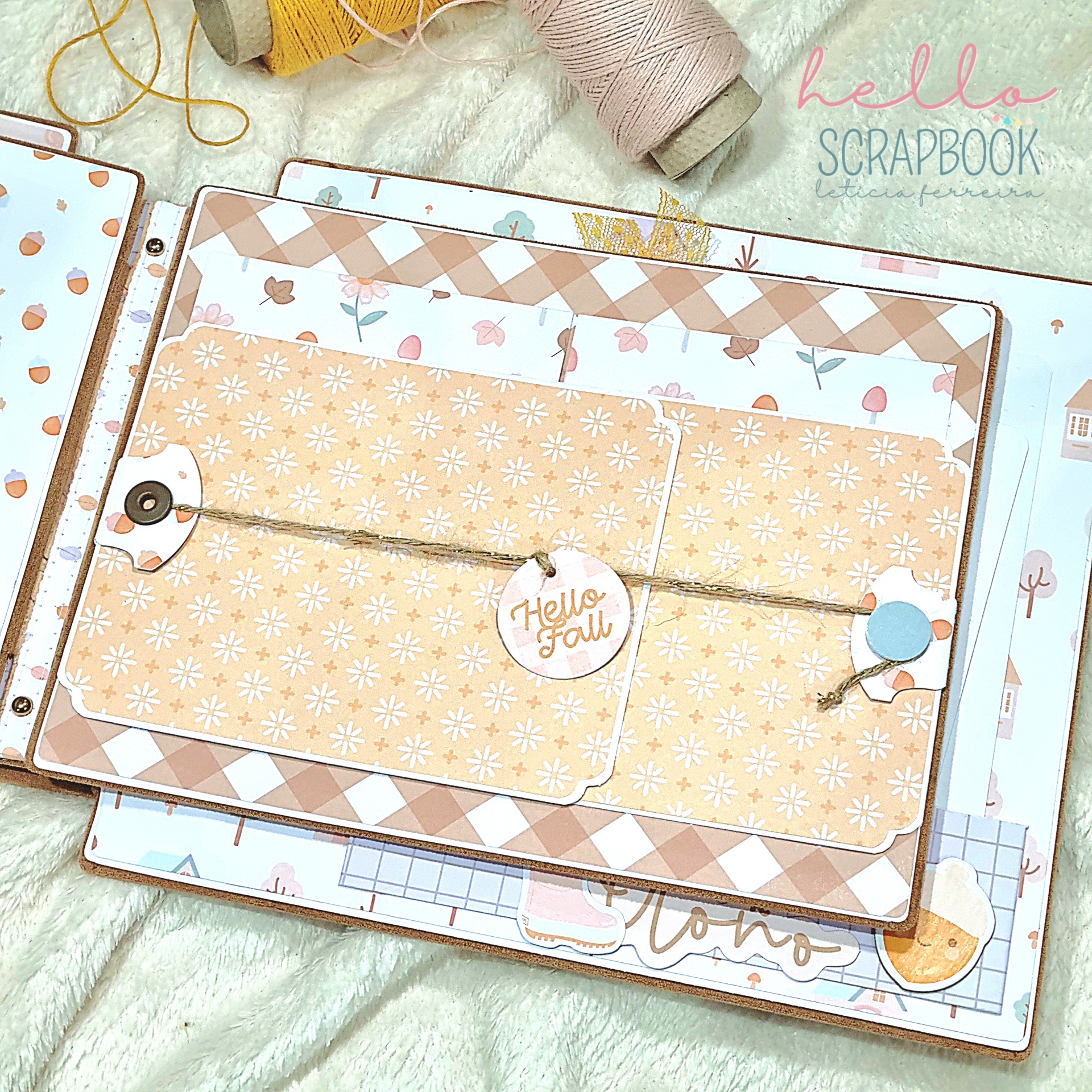 Álbum de scrapbook com motivos outonais em bege e castanho e fios de linha ao lado