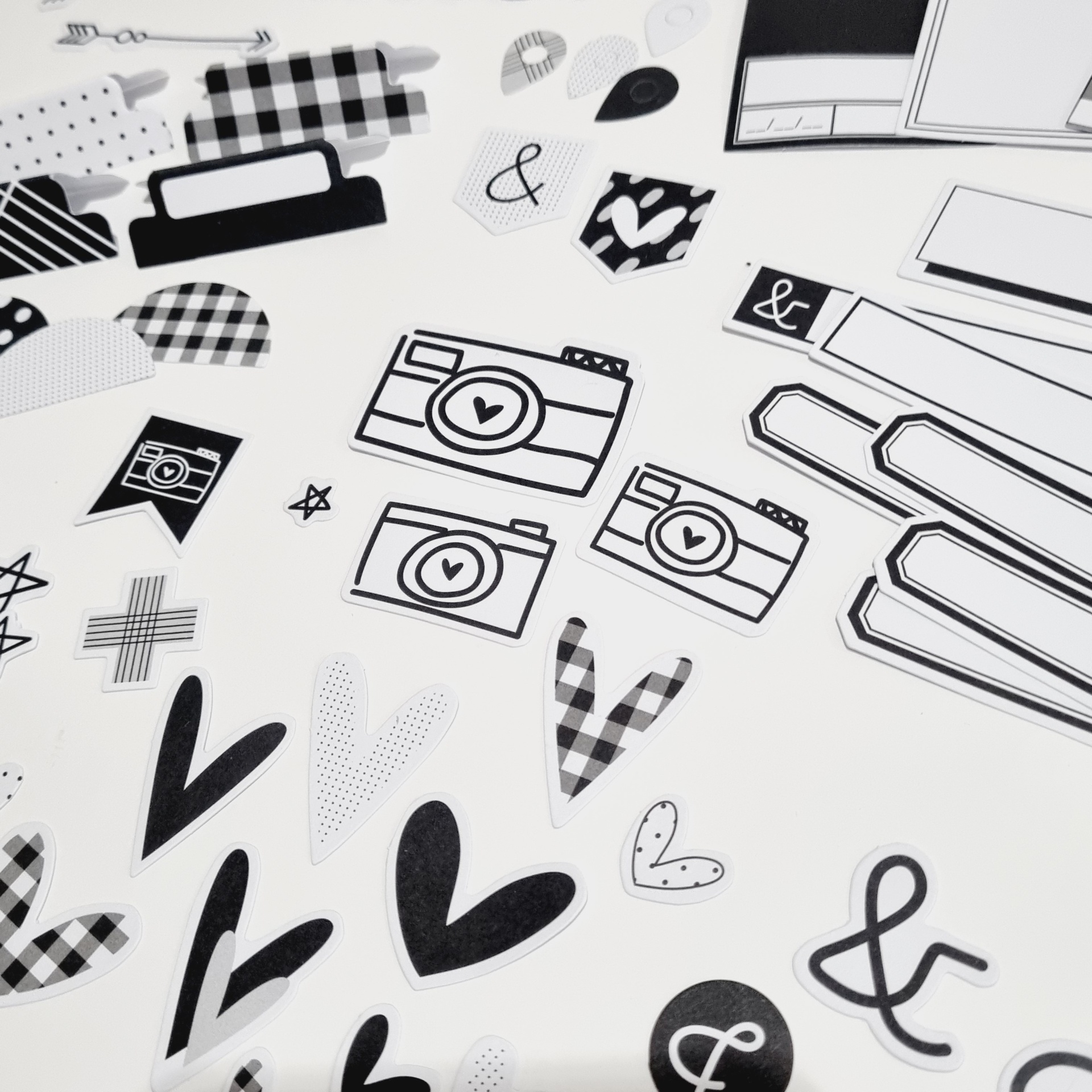 Autocolantes em preto, branco e xadrez com corações, câmaras e &