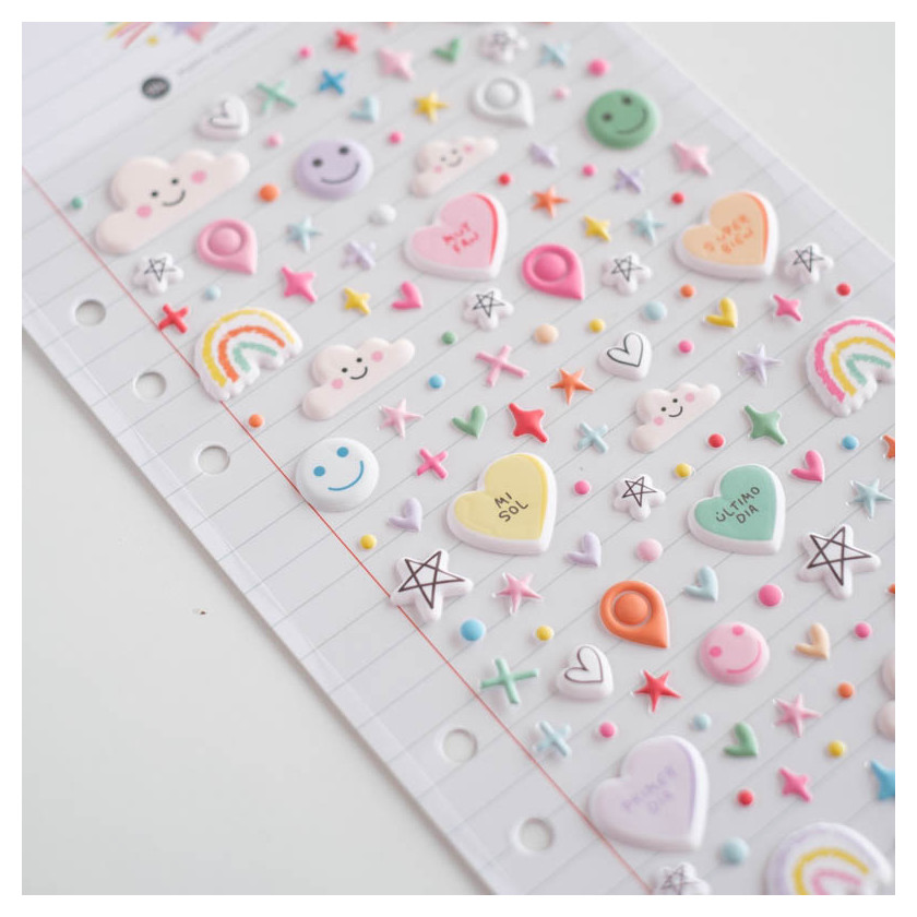 Folha com autocolantes em relevo coloridos com corações, rostos sorridentes, nuvens, estrelas, arco-íris e pontos.