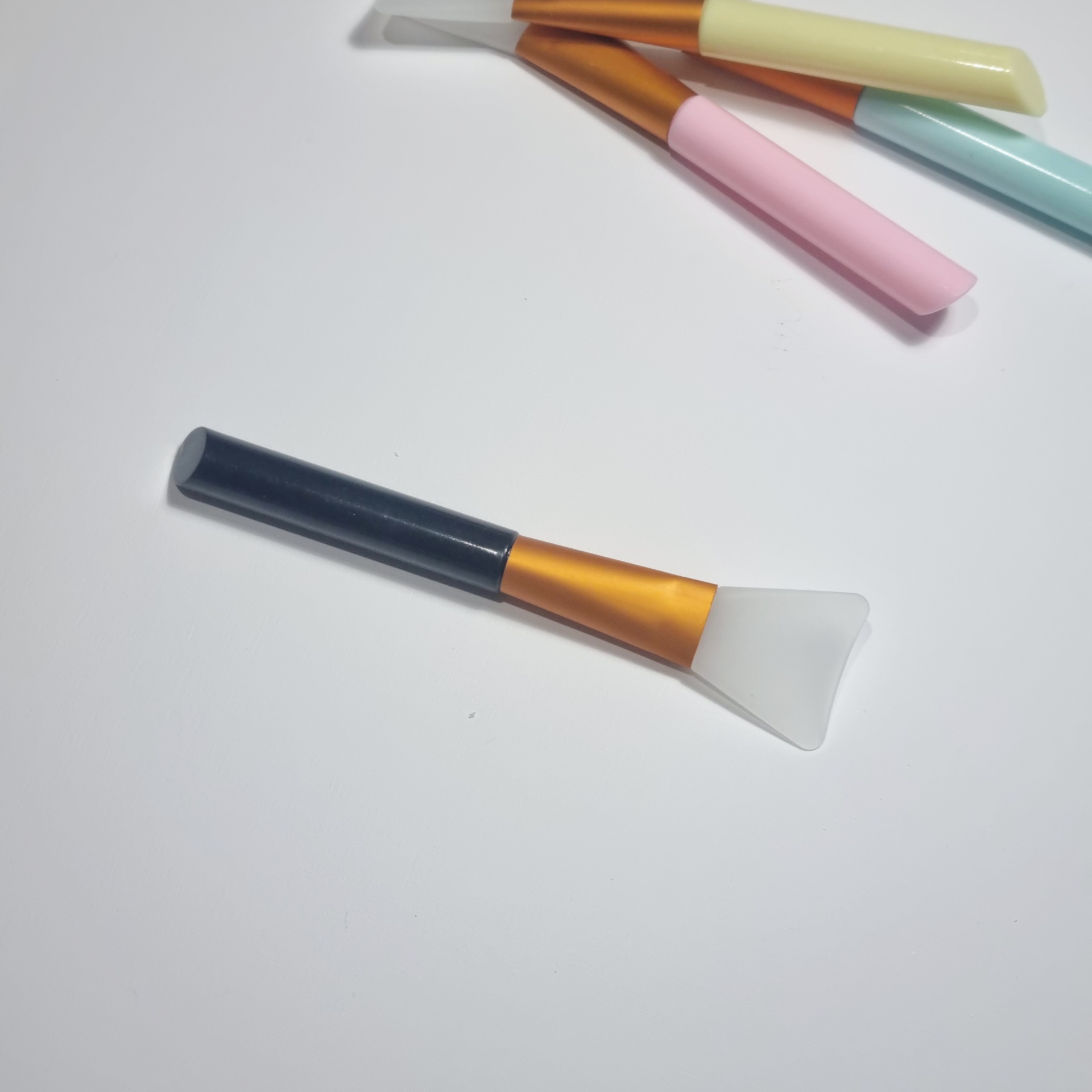 Pincéis de silicone com cabos coloridos em fundo branco