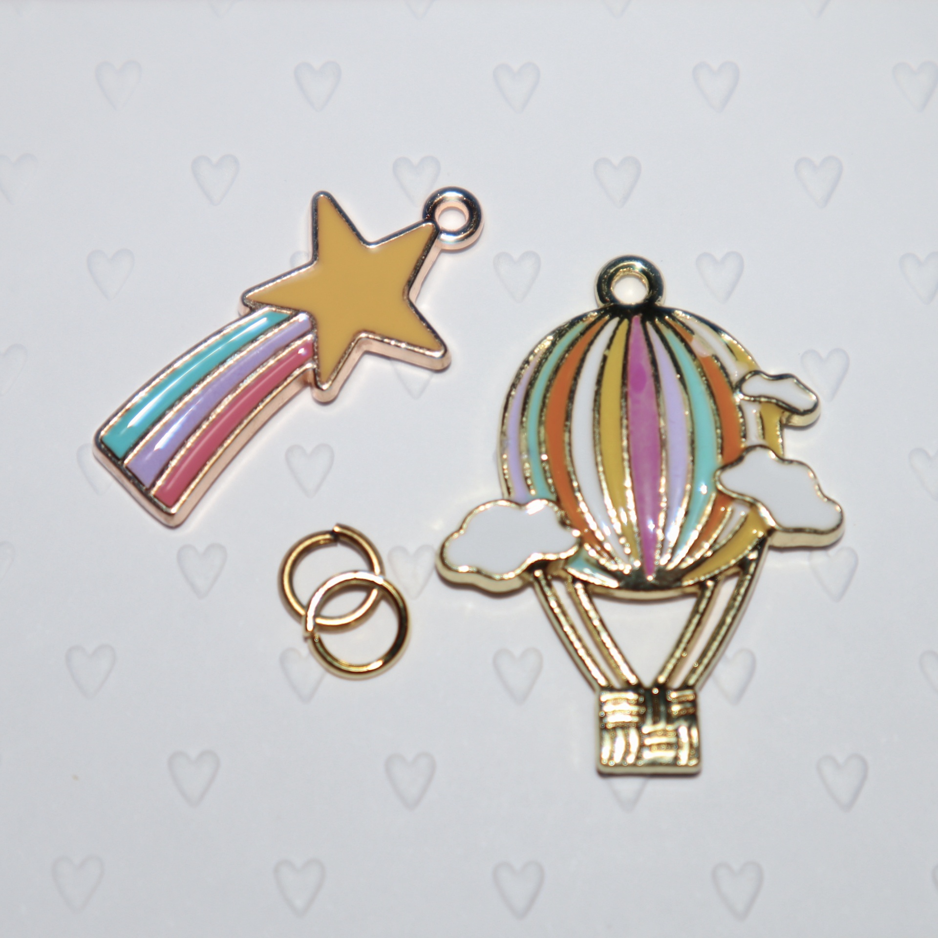 Pendentes coloridos em metal dourado com formas de estrela, balão de ar quente e anéis