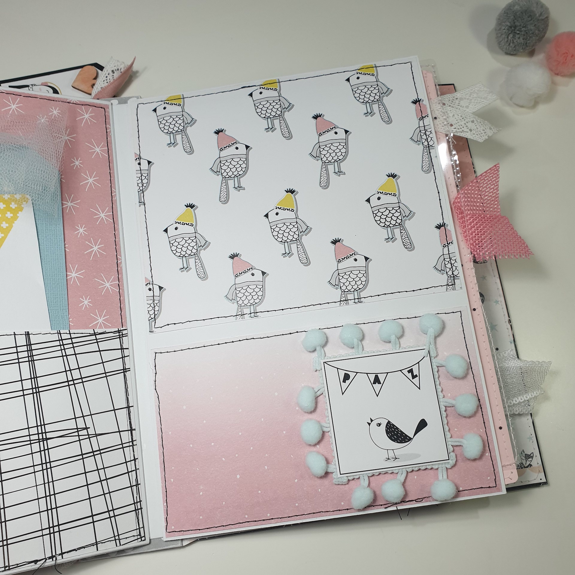 Livro artesanal com padrões de pássaros e detalhes em pompom azul