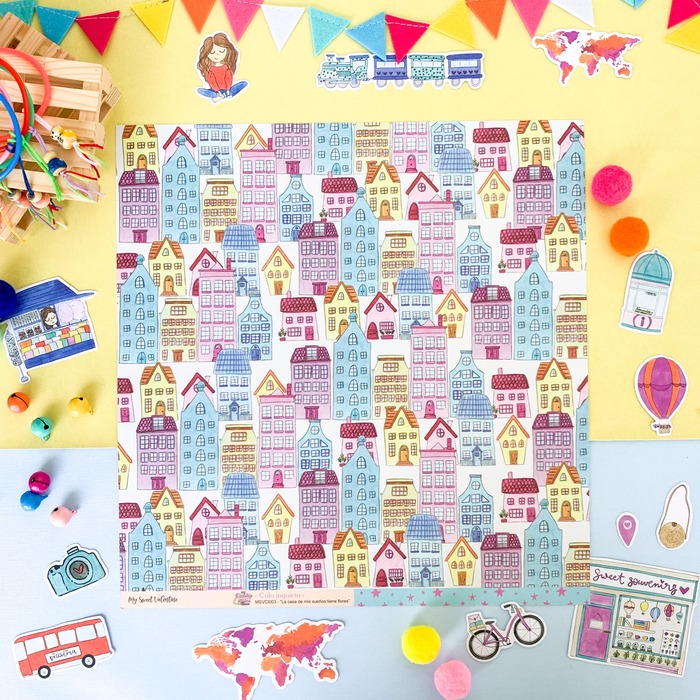 Folha com padrão de casas coloridas rodeada de miniaturas sobre fundo azul claro