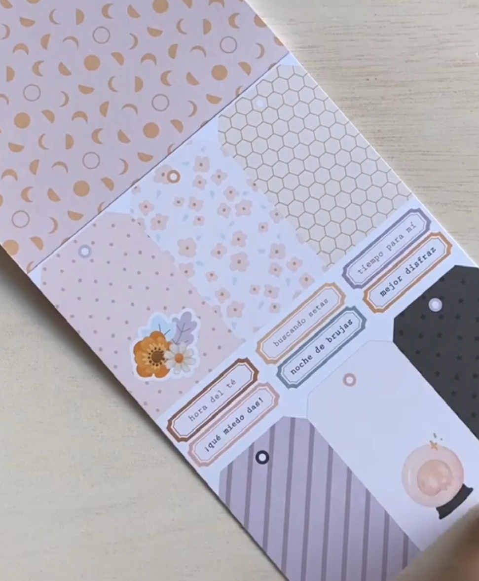 Folhas decorativas com padrões pastéis e etiquetas em espanhol sobre madeira clara