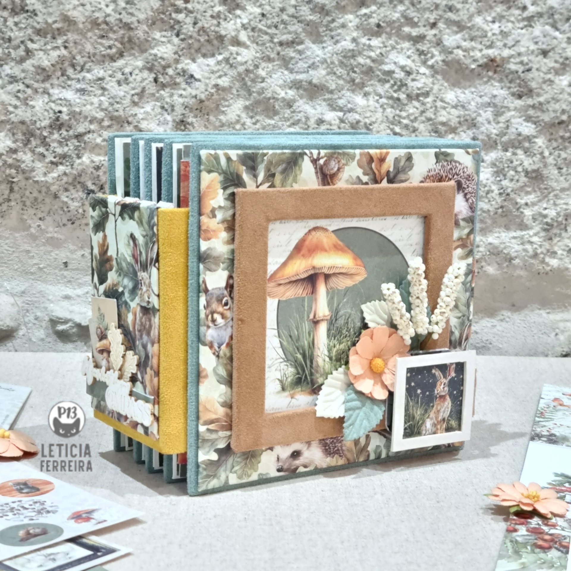 Álbum de scrapbook decorado com ilustração de cogumelo em relevo e elementos naturais artifíciais