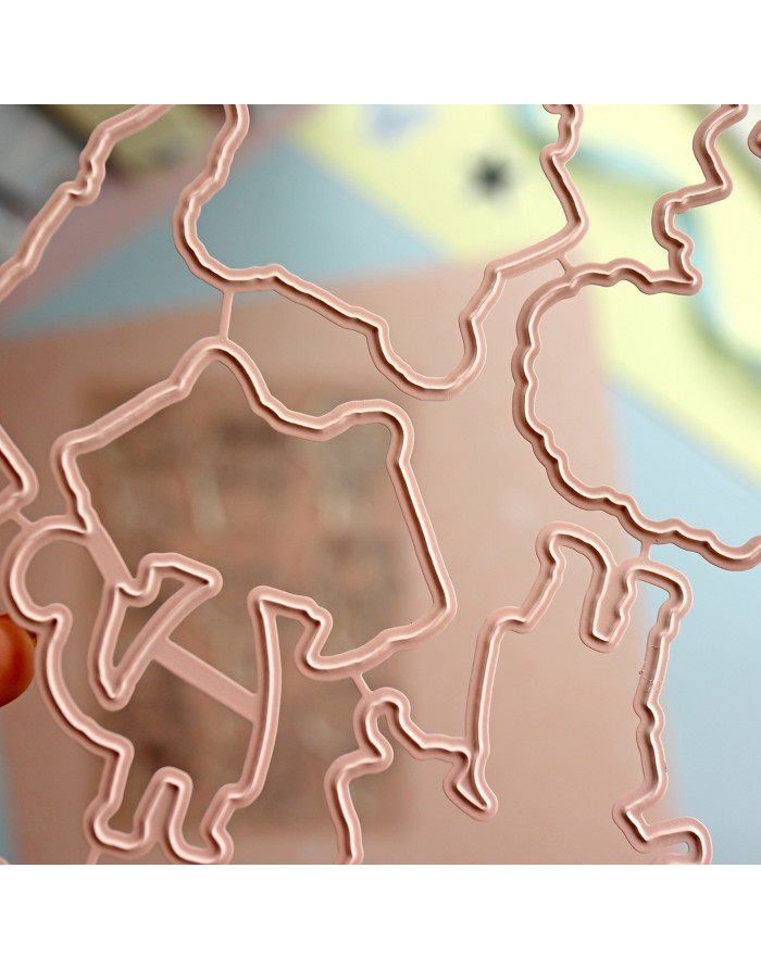 Molde plástico rosa com formas recortadas, segurado à mão