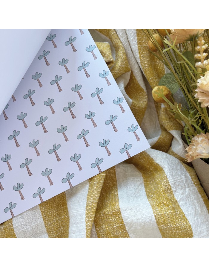 Papel decorativo com padrão de árvores ao lado de tecido listrado e flores secas