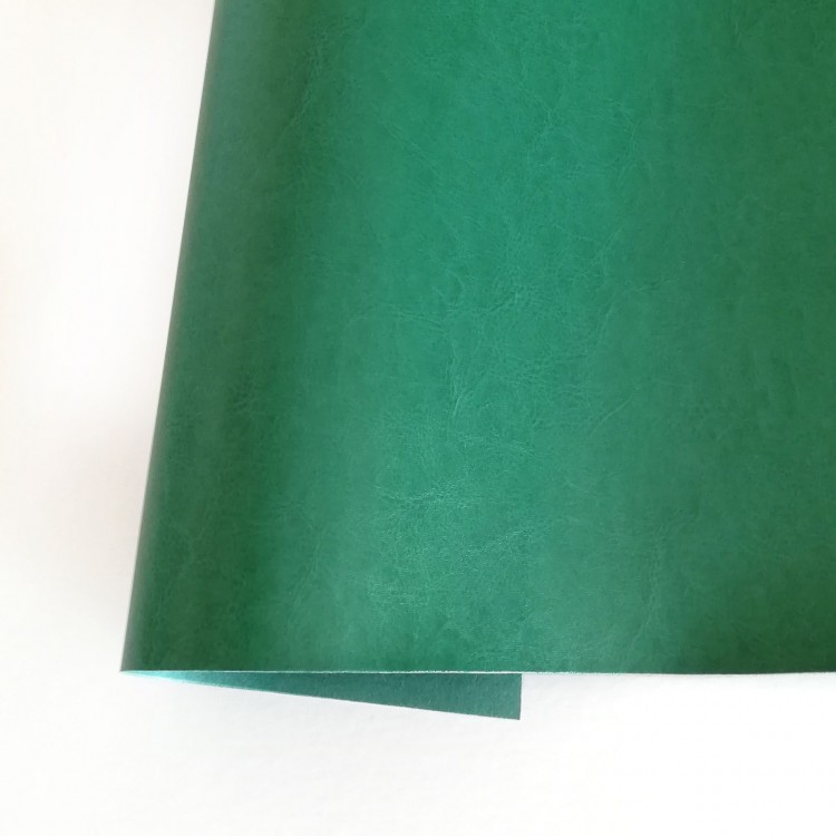 Papel verde texturado sobre fundo branco.