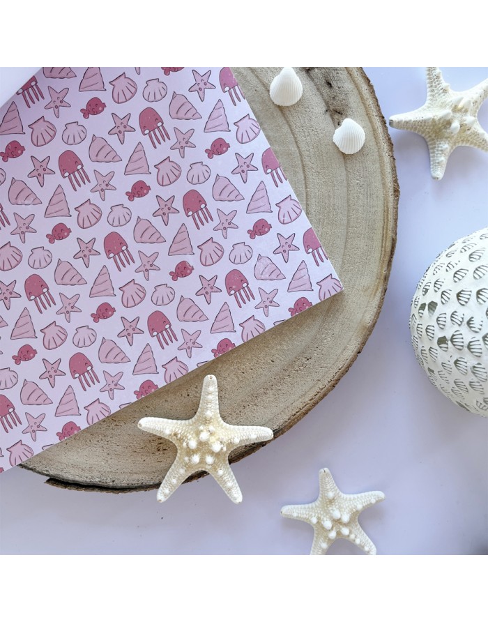 Cartão decorativo com padrão marítimo sobre tábua de madeira, conchas e estrelas-do-mar brancas ao redor