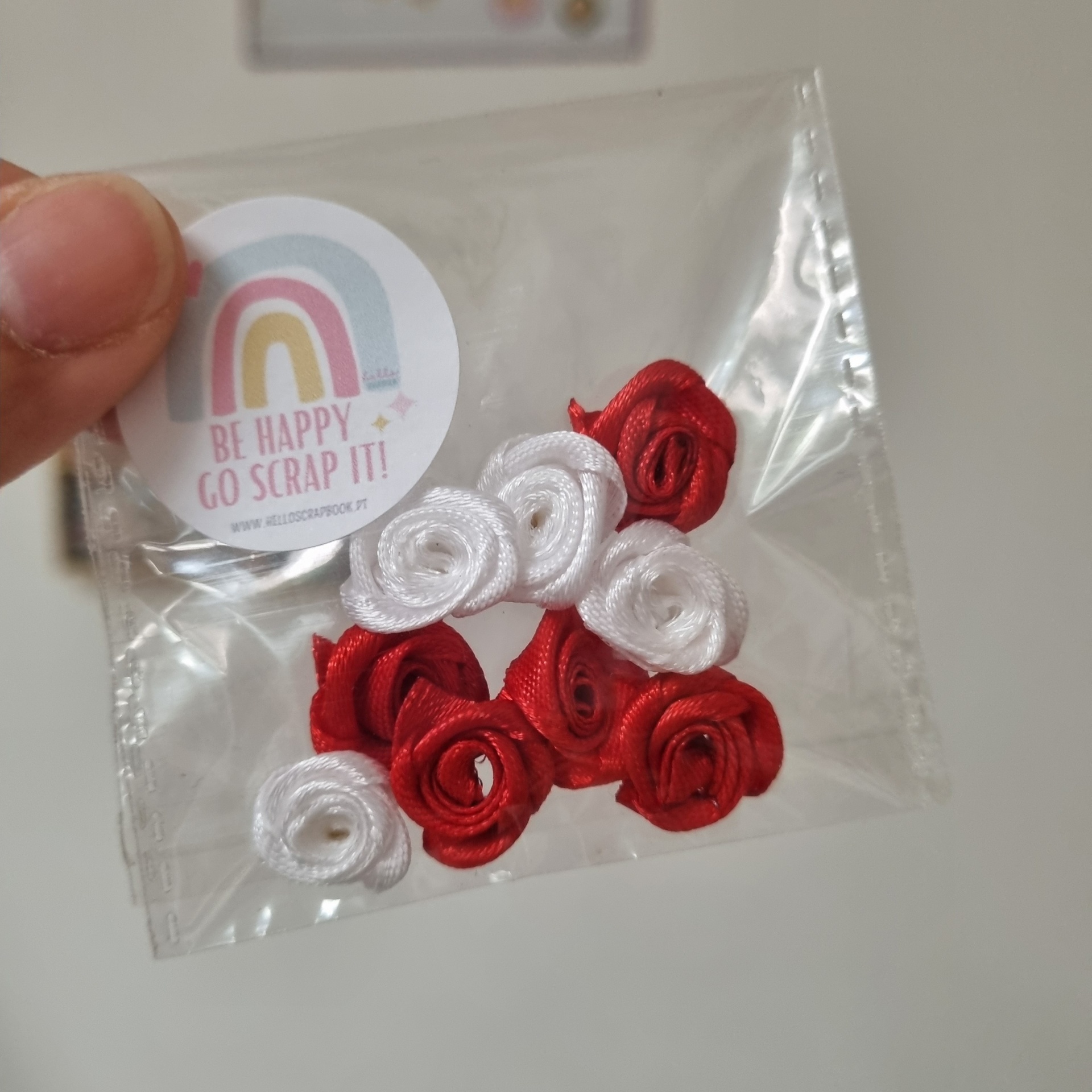 Flores decorativas vermelhas e brancas em pacote plástico com etiqueta colorida