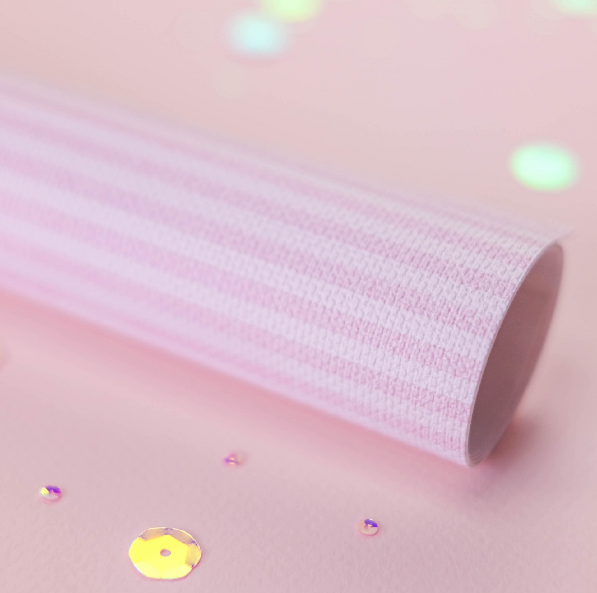 Rolo de papel ou tecido riscado rosa e branco com lantejoulas coloridas ao redor