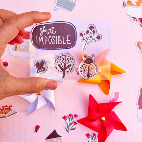 Conjunto de autocolantes com texto e desenhos coloridos em fundo rosa com cataventos de papel