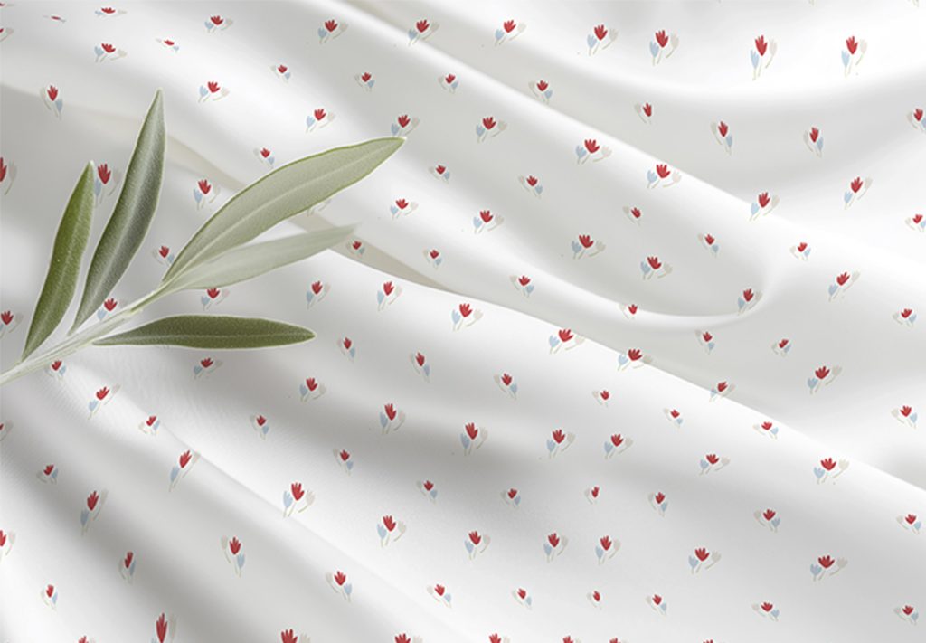 tecido branco com pequenas flores vermelhas e azul com folhagem verde em cima