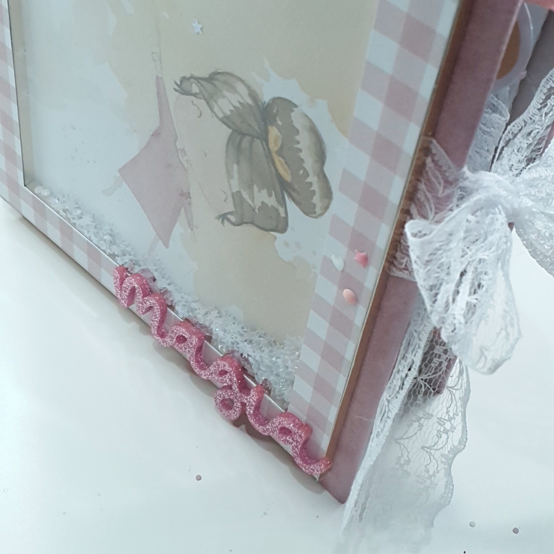 Moldura decorativa rosa xadrez com laço branco e imagem de anjo