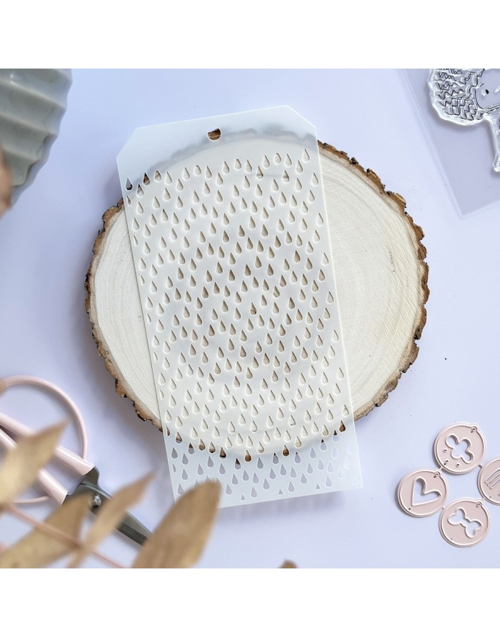 Stencil branco transparente com padrão de gotas recortadas sobre base redonda de madeira