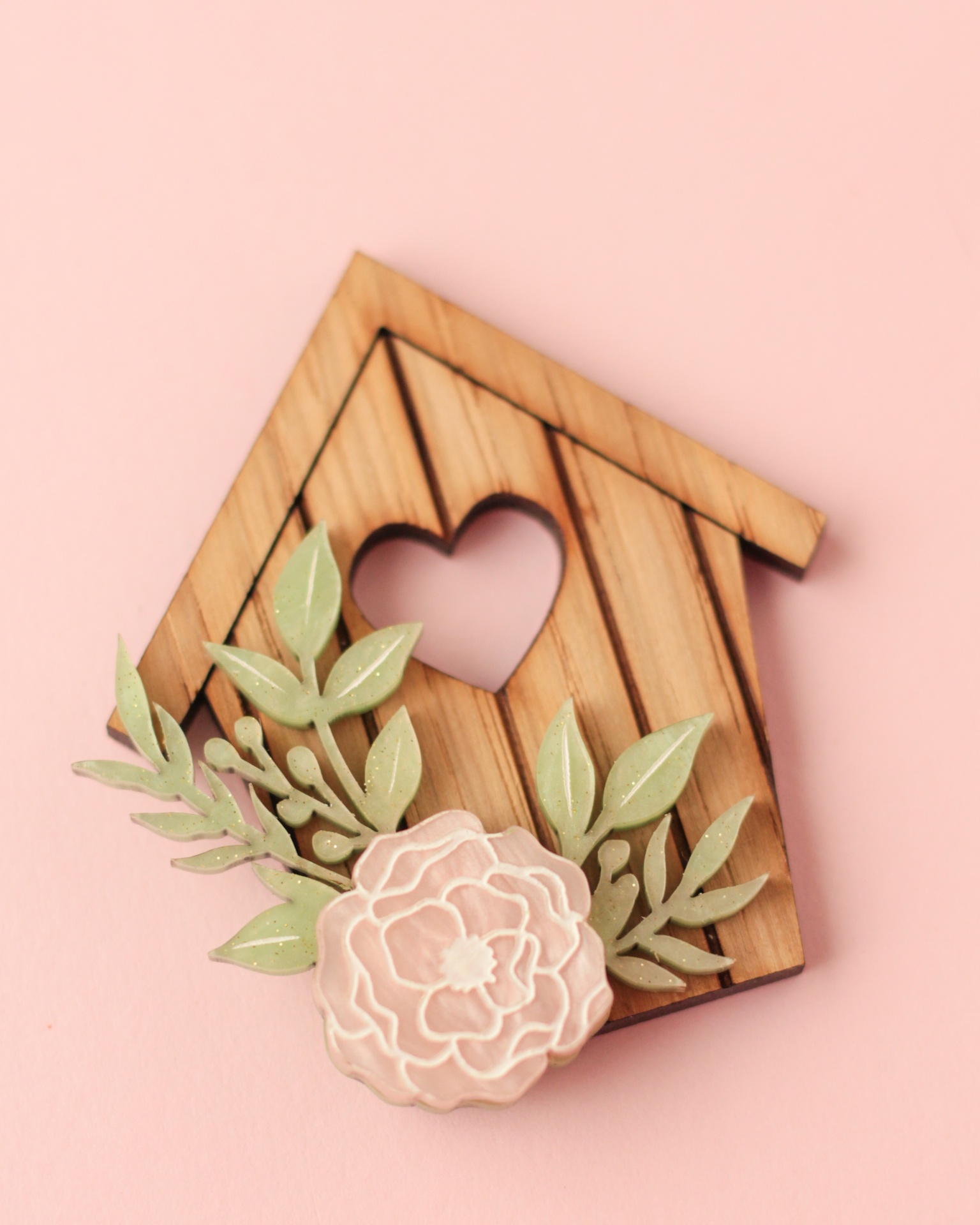 Broche decorativo de madeira em forma de casa com coração e flores