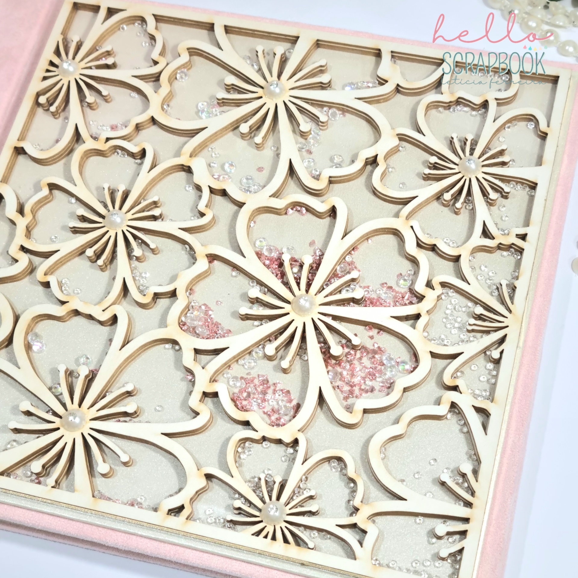 Quadro decorativo com flores de madeira clara e pedras translúcidas em moldura rosa