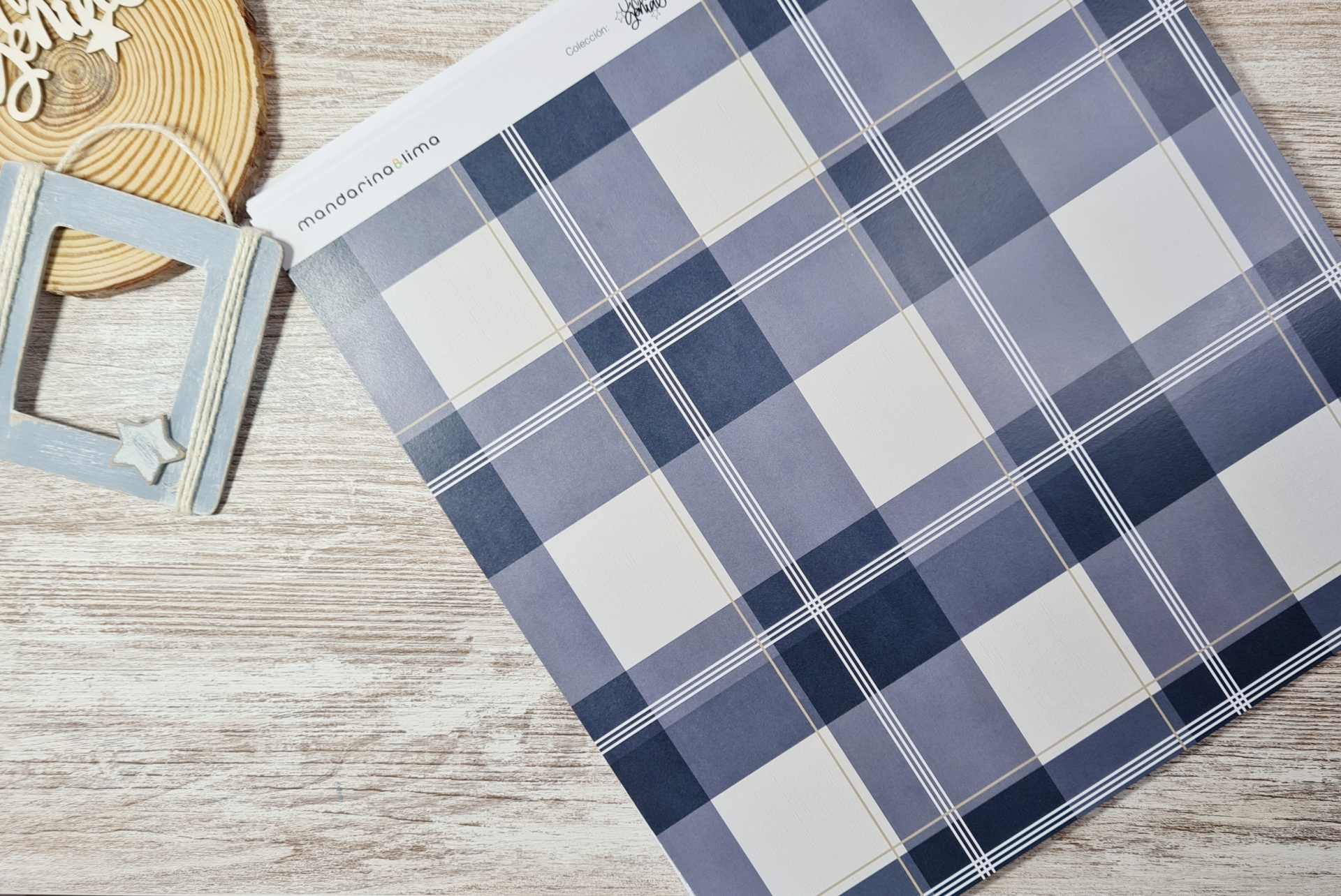 Folha de papel com padrão xadrez azul e branco sobre mesa de madeira com decoração