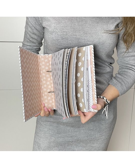 Pessoa a segurar álbum com páginas decoradas coloridas em tons pastel