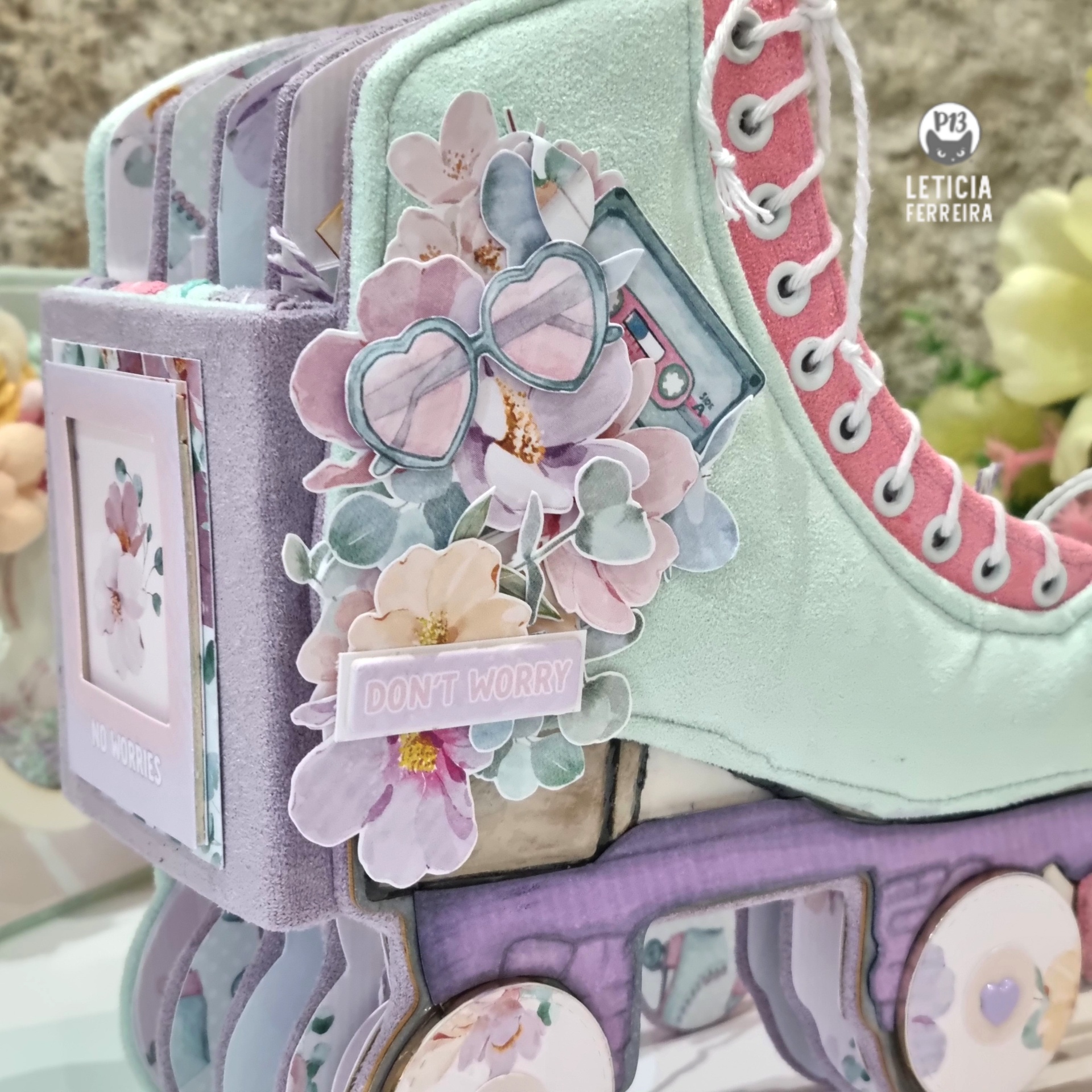 Mini álbum de fotos em formato de patins com cores pastel e decoração floral.