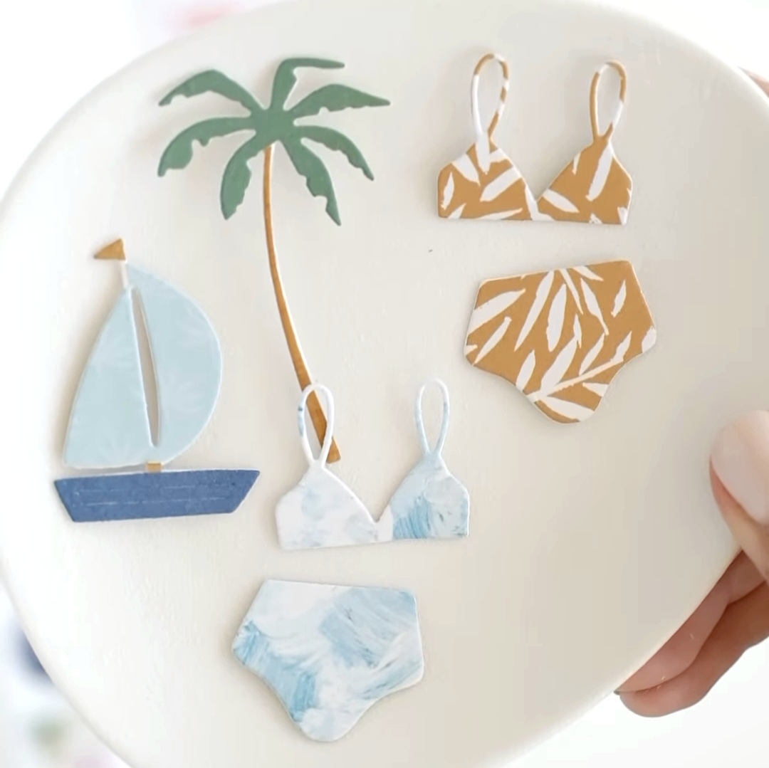 Prato branco com desenhos de bikinis, veleiro azul e palmeira verde em relevo